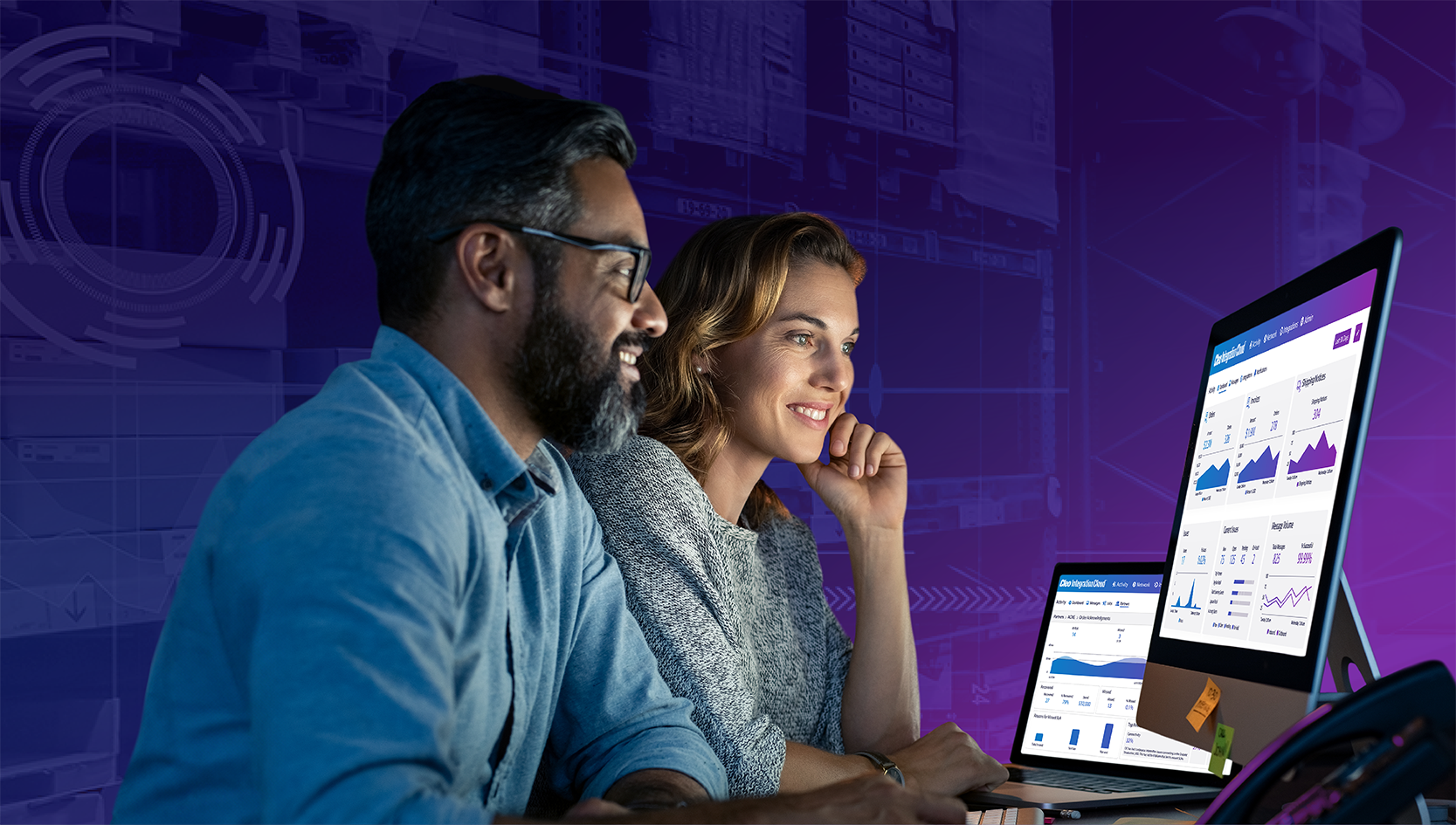 Two employees looking at desktop monitoring performance